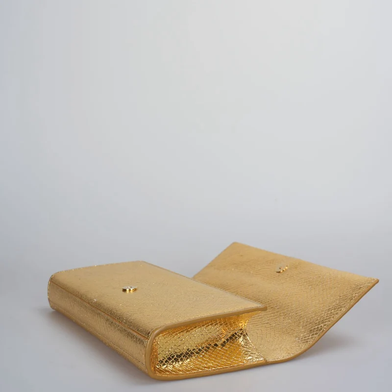 Saint Laurent – ​​Klassische Clutch aus goldmetallicfarbenem Kalbsleder mit geprägtem Monogramm und Quaste